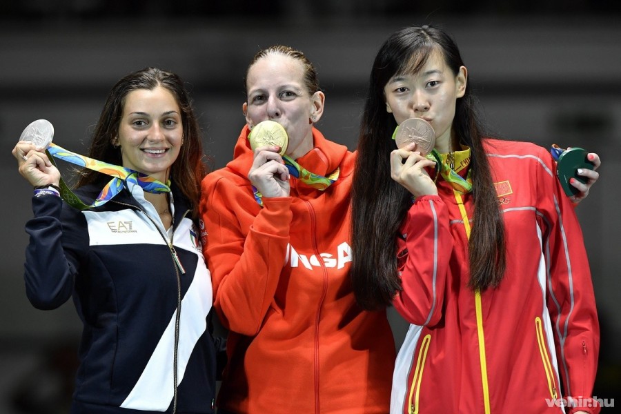 A párbajtőrben olimpia bajnok Szász Emese (k) megcsókolja aranyérmét az eredményhirdetésen, mellette a második helyezett olasz Rossella Fiamingo (b) és a bronzérmes kínai Szun Ji-ven a Rio de Janeiró-i 3-as Karióka Arénában 2016. augusztus 6-án. Szász Emese a 2016-os riói nyári olimpia női párbajtőrversenye döntőjében 15-13-ra győzött az olasz Rossella Fiamingo ellen. MTI Fotó: Czeglédi Zsolt 