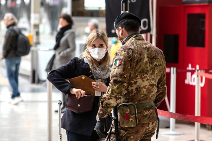 Egy olasz katona egy utassal beszél a milánói Milano Centrale vasútállomáson (kép: GETTY IMAGES)