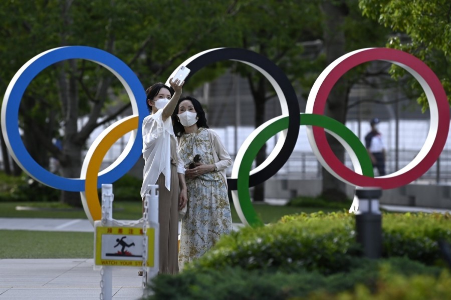 Helyiek fényképezkednek az olimpiai ötkarika előtt a megnyitóünnepség helyszíne, a tokiói Olimpiai Stadion közelében 2021. július 15-én - Fotó: MTI/Kovács Tamás